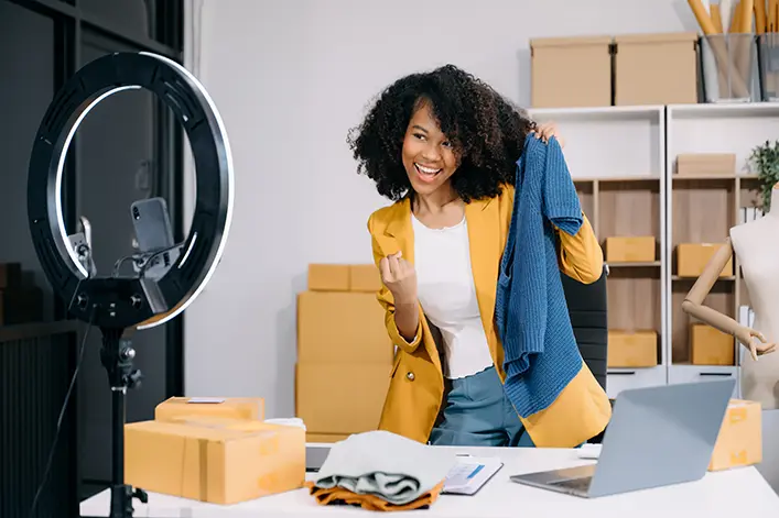 Emprendedora creando contenido para su tienda online mostrando productos ante una cámara
